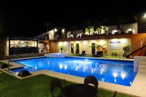 a large swimming pool at night with lights at Queens Hotel Angeles City in Angeles