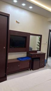 a bedroom with a bed and a large mirror at غرفه سويت مع مطبخ in Buraydah