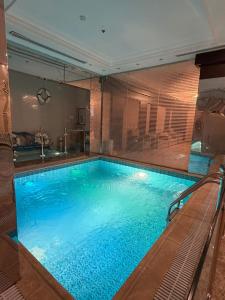 a large swimming pool in a building with at غرفه سويت مع مطبخ in Buraydah
