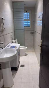 a bathroom with a sink and a toilet and a shower at غرفه سويت مع مطبخ in Buraydah
