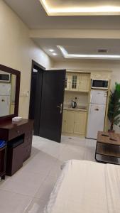 a kitchen with a black door and a white refrigerator at غرفه سويت مع مطبخ in Buraydah