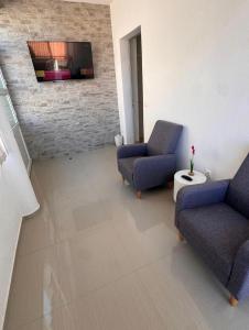 a living room with two chairs and a tv at Berulia rooms in Brela