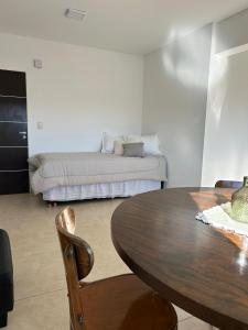 a living room with a table and a bed at Refugio Centro in Puerto Madryn