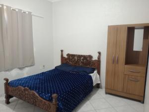 a bedroom with a bed and a wooden cabinet at Pousada Exclusiva in Rondonópolis +5 photos