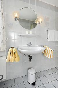 a white bathroom with a sink and a mirror at Ferienhaus Wattn Urlaub in Bensersiel