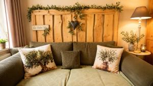 a couch with three pillows on top of it at Ferienwohnung Schmidtalien,inklusive Infrarotsauna in Dommitzsch +15 photos