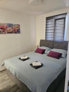 a bedroom with a large bed with towels on it at Tiny House Ciciban - self check in and check out in Otočac
