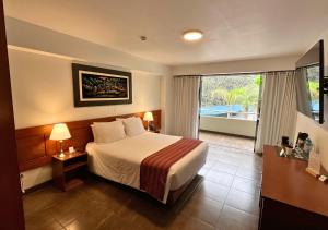a hotel room with a bed and a large window at Kankay Hotel y Centro de Convenciones in Cieneguilla