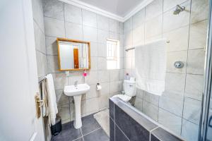 a bathroom with a sink and a toilet and a mirror at 13 Hobson in Secunda +21 photos