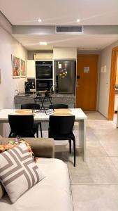 a living room with a couch and a table with chairs at Flat Paiva Bugam - Paiva Home Stay in Recife