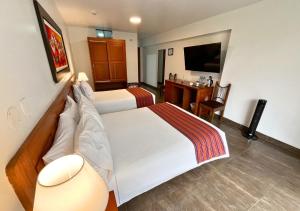 a hotel room with a bed and a desk at Kankay Hotel y Centro de Convenciones in Cieneguilla