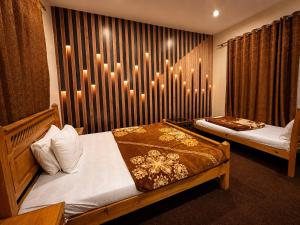 a bedroom with two beds and candles on the wall at The Comfy By Hotel Mountain Track in Taranna