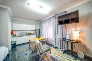 a living room with a table and a kitchen at 13 Hobson in Secunda