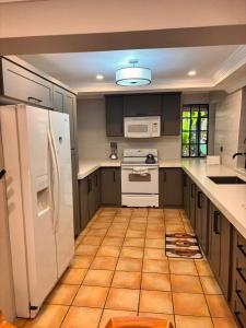 a kitchen with white appliances and a tile floor at Serenity Garden Escape in Port-of-Spain