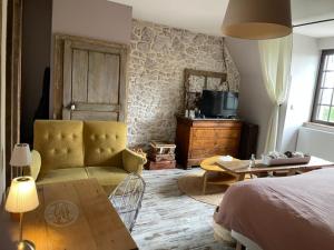 a bedroom with a bed and a couch and a table at Bienvenue chez Chris ! in Saint-Hilaire-des-Landes