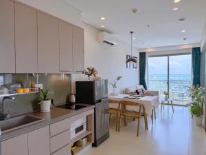 a kitchen and dining room with a table and a kitchen and a dining room at The Song Apartment - Căn Hộ Du Lịch 5 Sao Cạnh Biển Vũng Tàu in Vung Tau