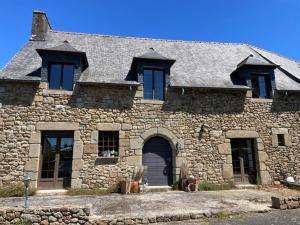 a large stone house with a large door at Bienvenue chez Chris ! in Saint-Hilaire-des-Landes