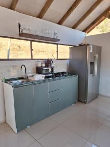 a kitchen with a stove and a refrigerator at Tu rinconcito entre cerros in Requínoa