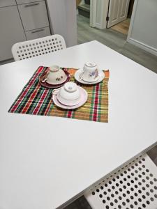a white table with plates and cups on a rug at CozyHaven in St. Catharines
