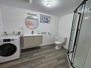a bathroom with a washing machine and a toilet at CozyHaven in St. Catharines +39 photos
