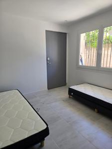 a room with two beds and a window and a door at Yamna in Perpignan