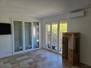 a living room with windows and a box in it at Yamna in Perpignan