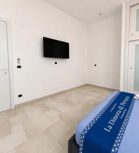 a room with a bed and a tv on a wall at ladimoradiperseo in Giovinazzo