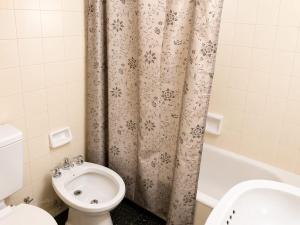 a bathroom with a toilet and a shower curtain at Peatonal Sarmiento in Mendoza +5 photos