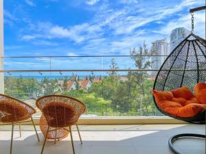 a balcony with chairs and a large window at The Song Apartment - Căn Hộ Du Lịch 5 Sao Cạnh Biển Vũng Tàu in Vung Tau