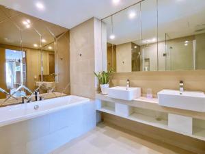a bathroom with two sinks and a tub and a mirror at The Song Apartment - Căn Hộ Du Lịch 5 Sao Cạnh Biển Vũng Tàu in Vung Tau +74 photos