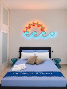 a bedroom with a blue bed with lights on the wall at ladimoradiperseo in Giovinazzo