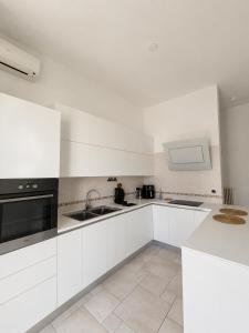 a white kitchen with a sink and a microwave at ladimoradiperseo in Giovinazzo