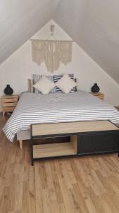 a bedroom with a bed with a wooden floor at Ty ar C'hoad in Sulniac