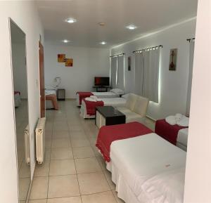 a hotel room with three beds and a tv at Hostería Boulevard in Villa María +2 photos