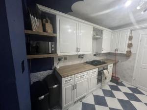 a kitchen with white cabinets and a checkered floor at Gravesend Central - Spacious & Quiet Rooms in Gravesend