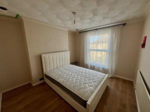 a bedroom with a white bed and a window at Gravesend Central - Spacious & Quiet Rooms in Gravesend