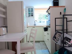 a kitchen with a white table and two chairs at Ferienwohnung unterm Kirschbaum in Großenlüder +7 photos