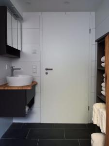a bathroom with a sink and a white door at Ferienwohnung unterm Kirschbaum in Großenlüder