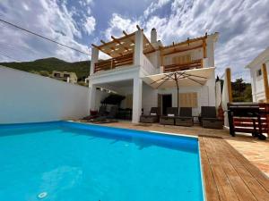 a villa with a swimming pool and a house at Sea La Vie in Nikiana