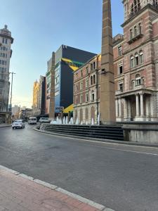 a building with a fountain in the middle of a street at Apartment in joburg in Johannesburg