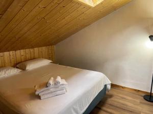 a bedroom with a bed with towels on it at Residence Rododendro in Passo San Pellegrino