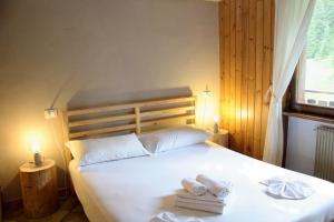 a bedroom with a bed with towels on it at Residence Rododendro in Passo San Pellegrino +18 photos