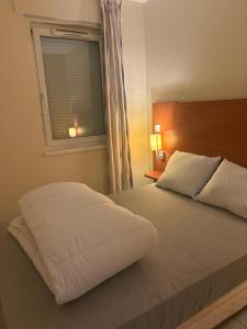 a bedroom with a large bed with a window at Chalet gris 4 in Chaveignes