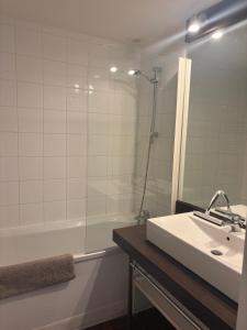 a bathroom with a sink and a shower and a tub at Chalet gris 4 in Chaveignes