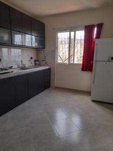 a kitchen with a white refrigerator and a window at calm appart in Agadir