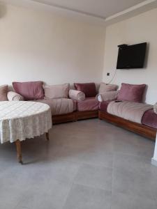 a living room with a couch and a tv at calm appart in Agadir