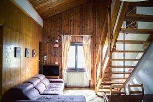 a living room with a couch and a staircase at Residence Rododendro in Passo San Pellegrino