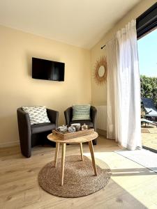 a living room with a coffee table and a chair at Le Cocon de May entre Terre et Mer a proximité de caen in May-sur-Orne