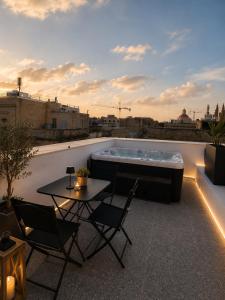 a hot tub on a rooftop with a table and chairs at Kappuccini Hill boutique hotel - By Tritoni Hotels in Il-Furjana +55 photos