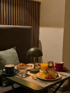 a table with breakfast foods and orange juice on it at Kappuccini Hill boutique hotel - By Tritoni Hotels in Il-Furjana